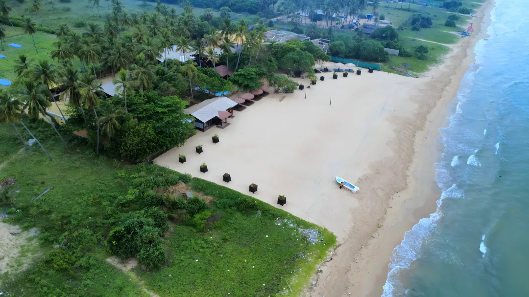 An original aerial view of the resort beside the wide mainland beach and Indian Ocean