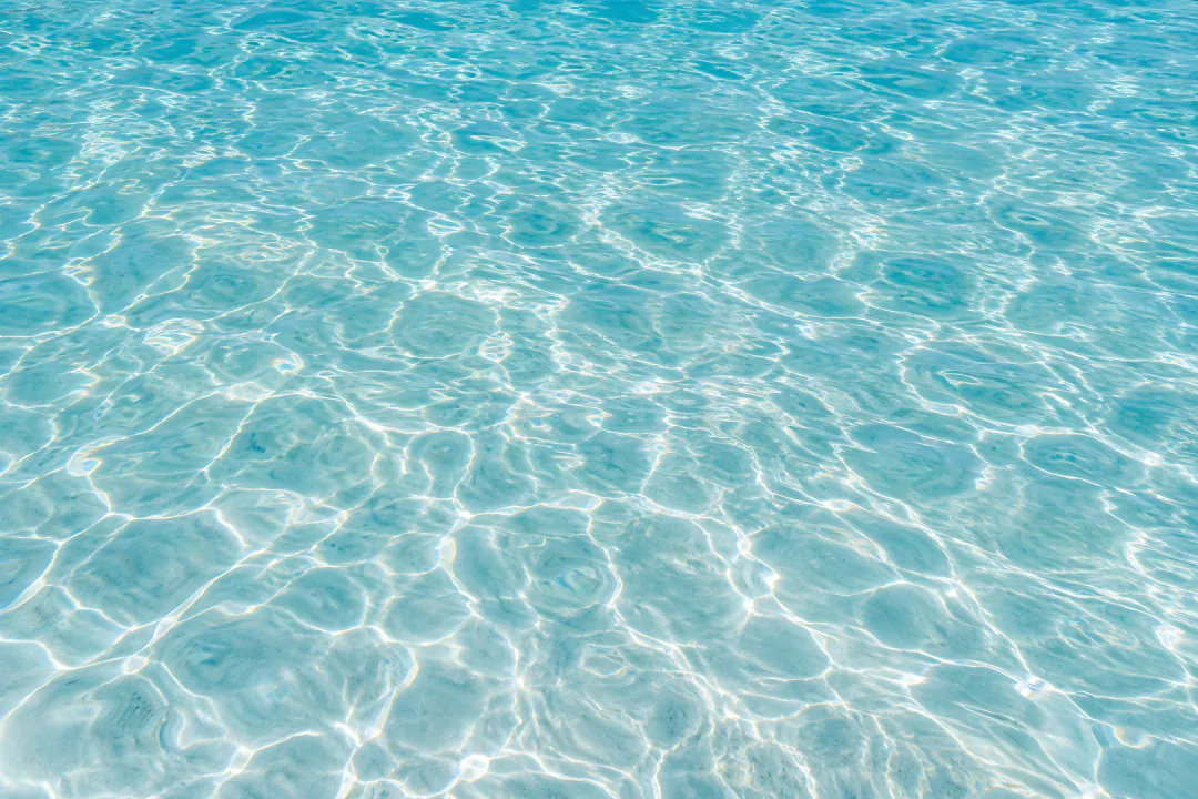 Turquoise water over white sand with soft light ripples